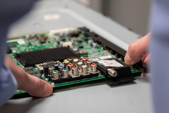 hands holding a circuit board.
