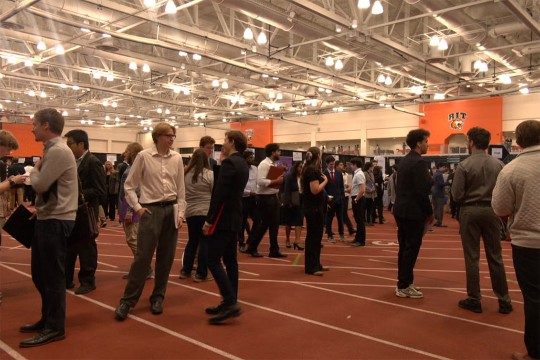 students mill around the floor at a career fair at R I T