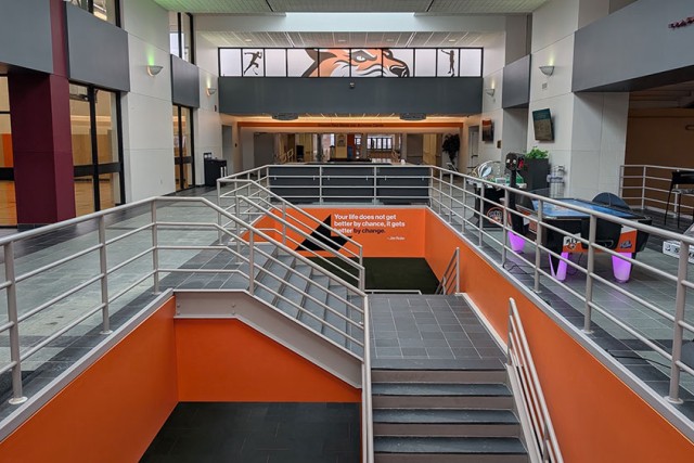 lobby area with an air hockey table and stairways that lead to a lower level.