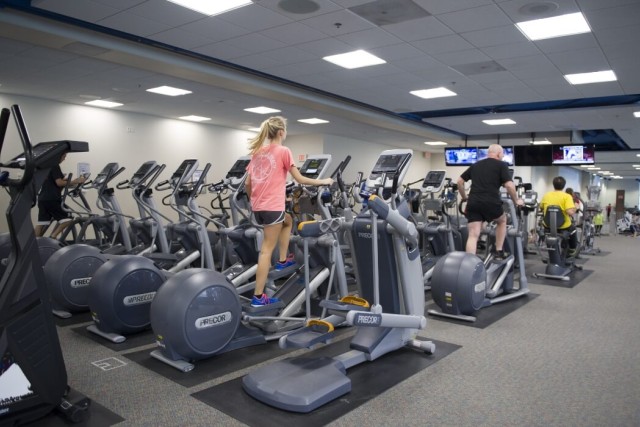 Two rows of ellipticals in the Wiedman Fitness Center with people using the exercise machines