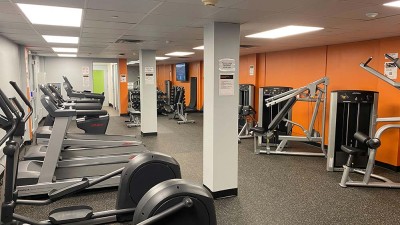 a gym space with cardio equipment, weight lifting equipment, and free weights.