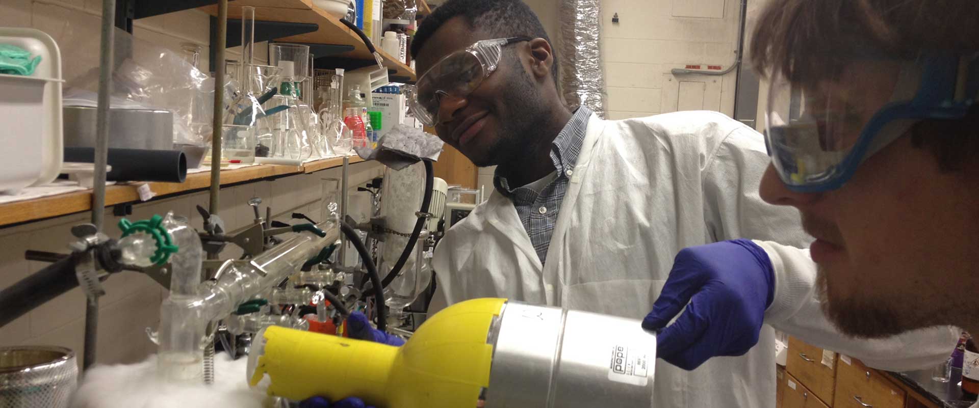 Students in lab pouring liquid into an experiment.