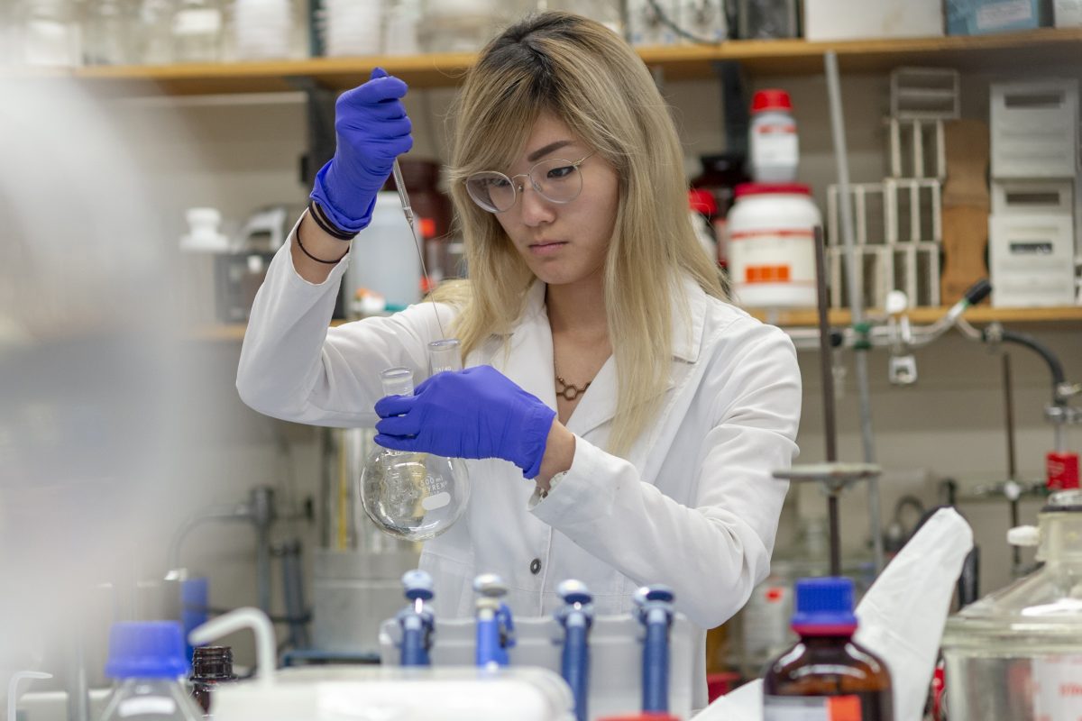 student measuring liquid in test tubes