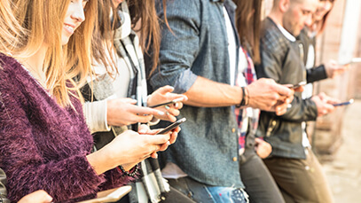 4 people looking at their smartphones