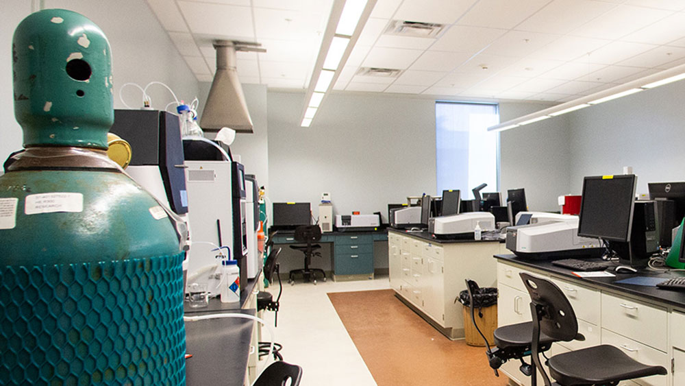 A well-equipped analytical laboratory with gas tanks and scientific instruments.