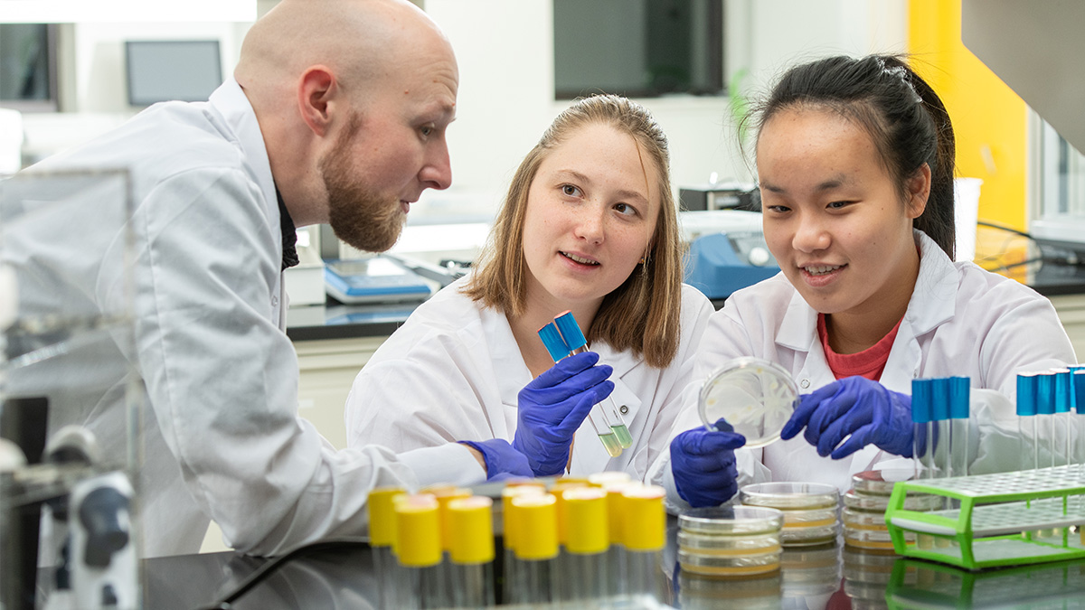 Professor working with two students in a lab
