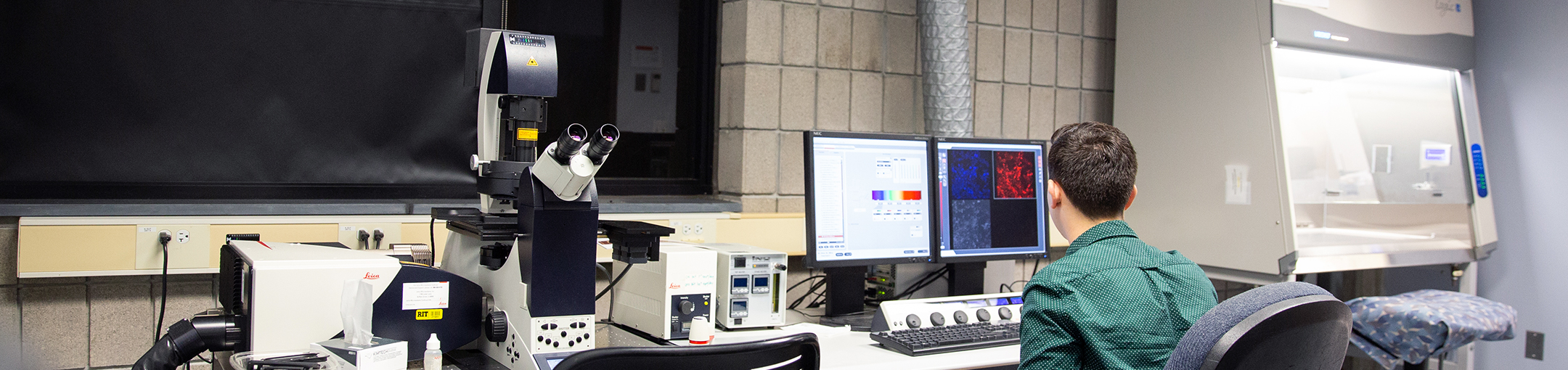 male student sitting in confocal microscopy lab