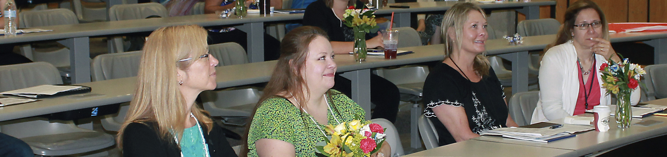 women sitting in a classroom during a conference