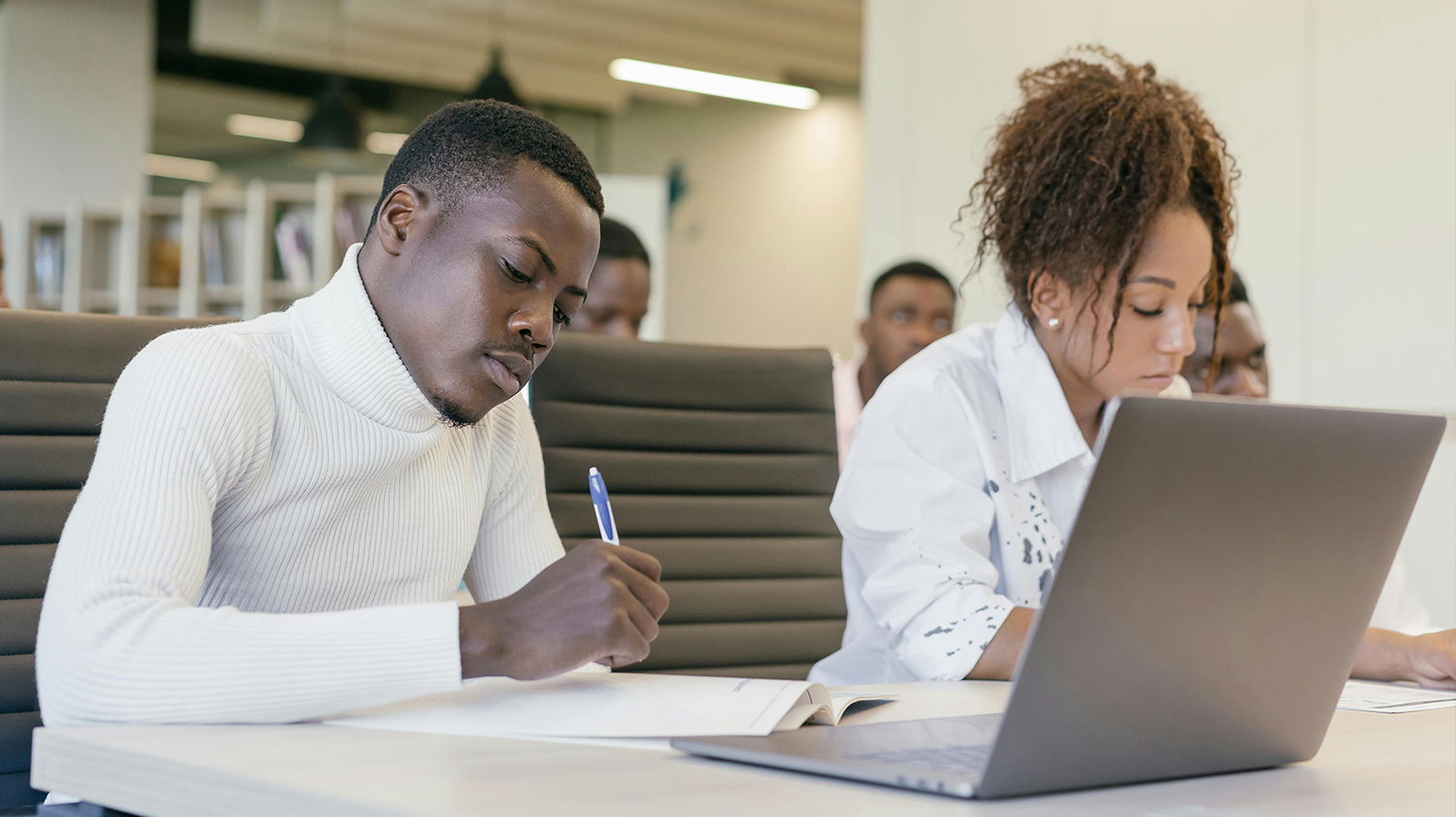 two students working on their laptops