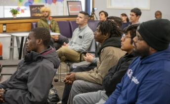 Several R I T students sitting in chairs during a workshop.