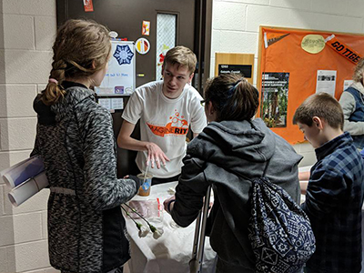 students and visitors at ImagineRIT exhibit