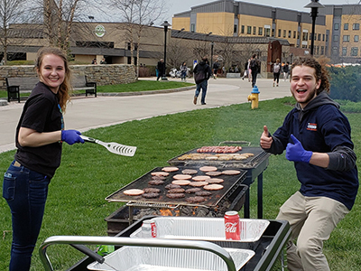 college students at picnic cooking burgers