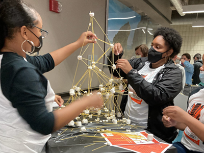students building a spaghetti tower at Brick City Weekend
