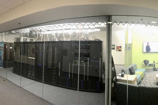 Glass walled room looking at server racks