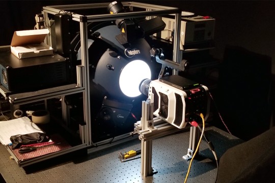 calibration instrument with a camera pointed toward a glowing orb.