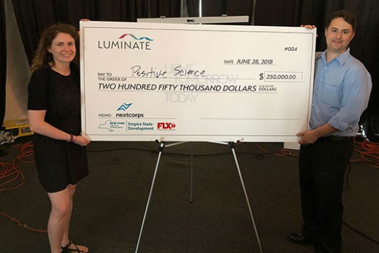 Two people holding large check.
