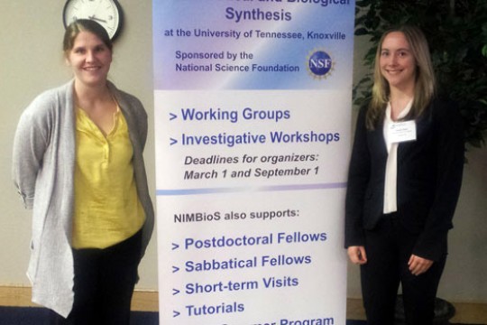 People posing next to display