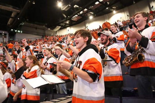 Elise Walsh with RIT Pep band all dressed in RIT Jerseys.