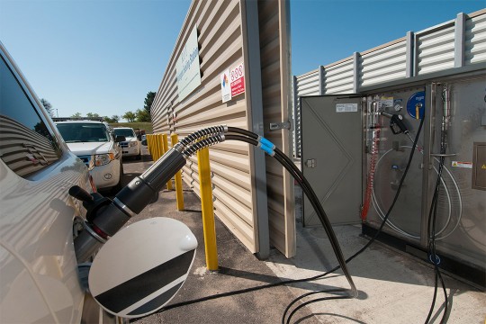 car plugged into hydrogen fueling station.