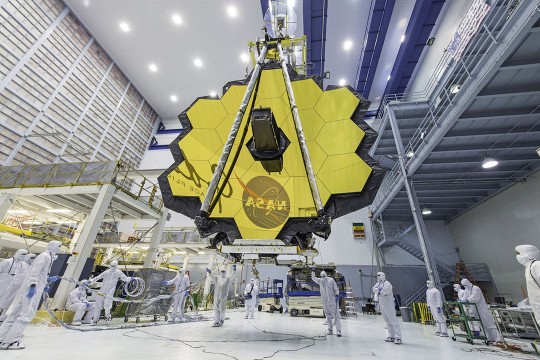 a crane lifting the James Webb Space Telescope.