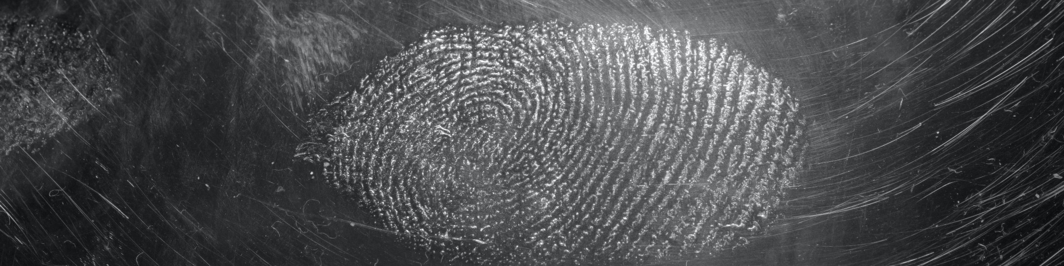 Grey fingerprint on a black glass type background