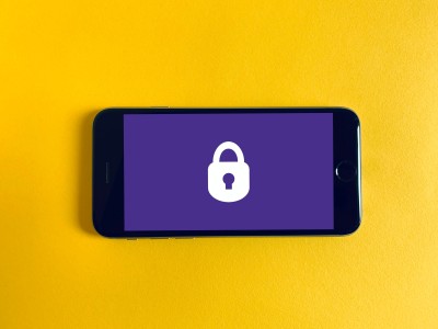 Phone screen on a yellow background showing lock icon