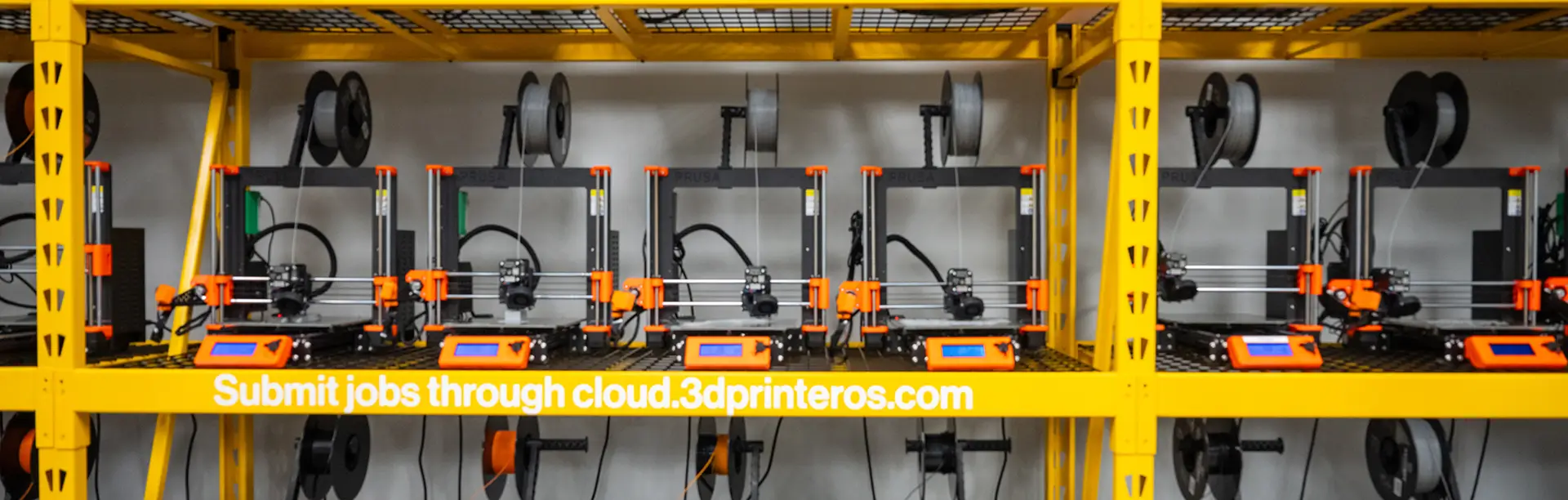 Yellow shelving units full with 3D printers.