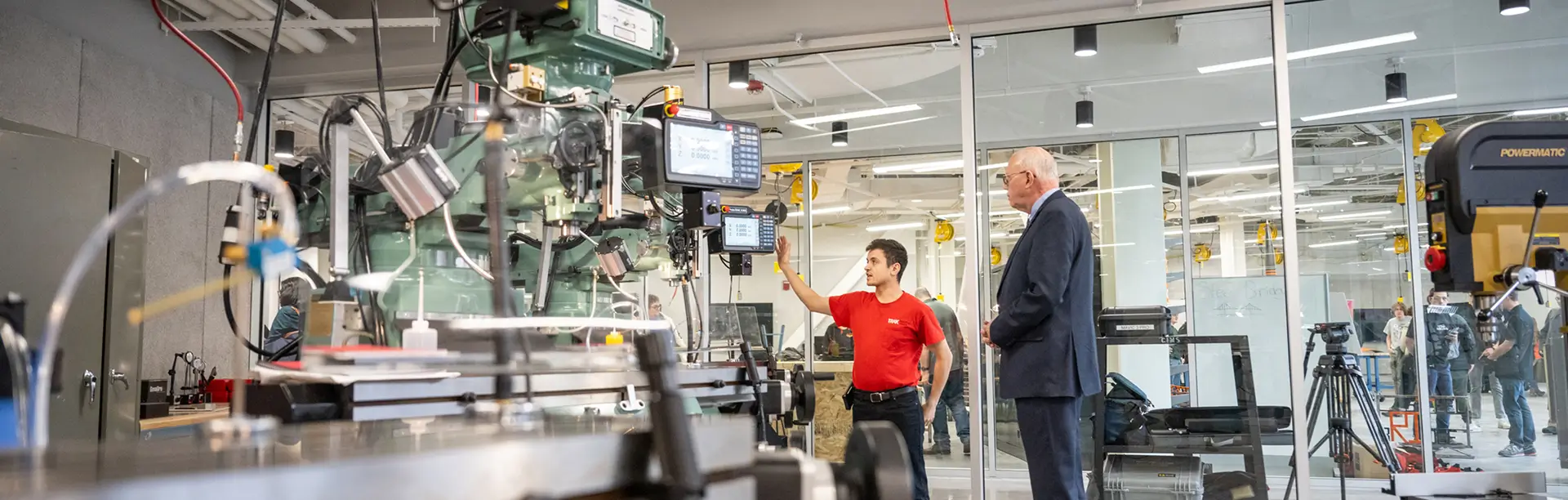 David Munson and another person stand next to a fabrication machine in the SHED A-Level Open Makerspace.