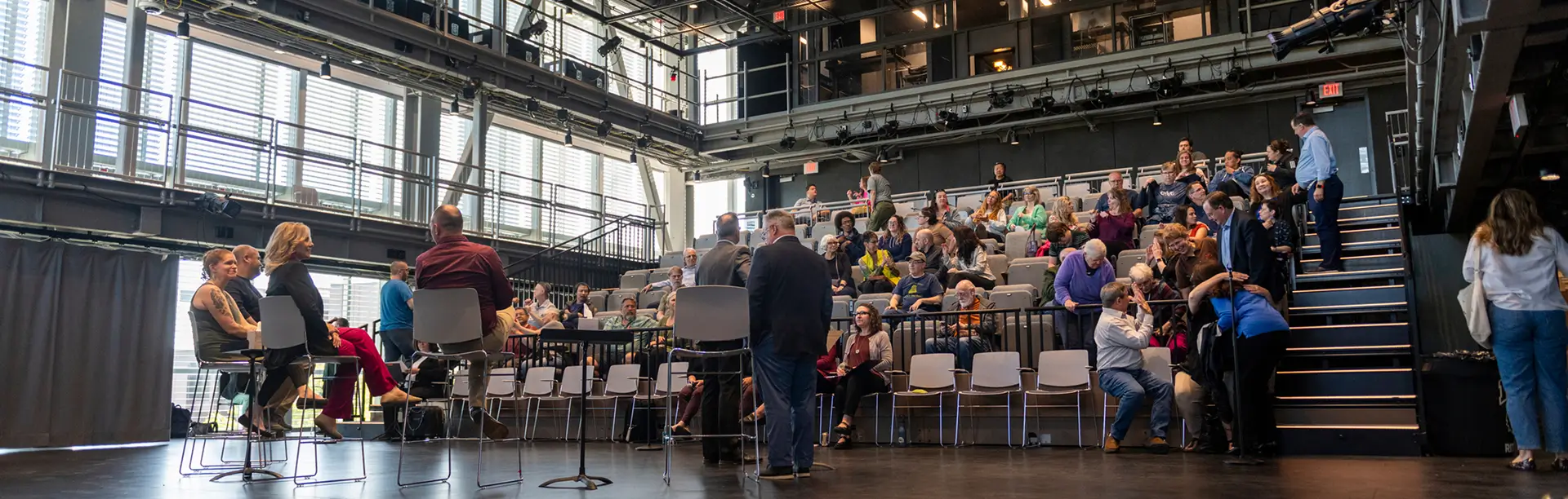 The view from the stage of an audience watching a roundtable discussion in the Sklarsky Glass Box Theater.