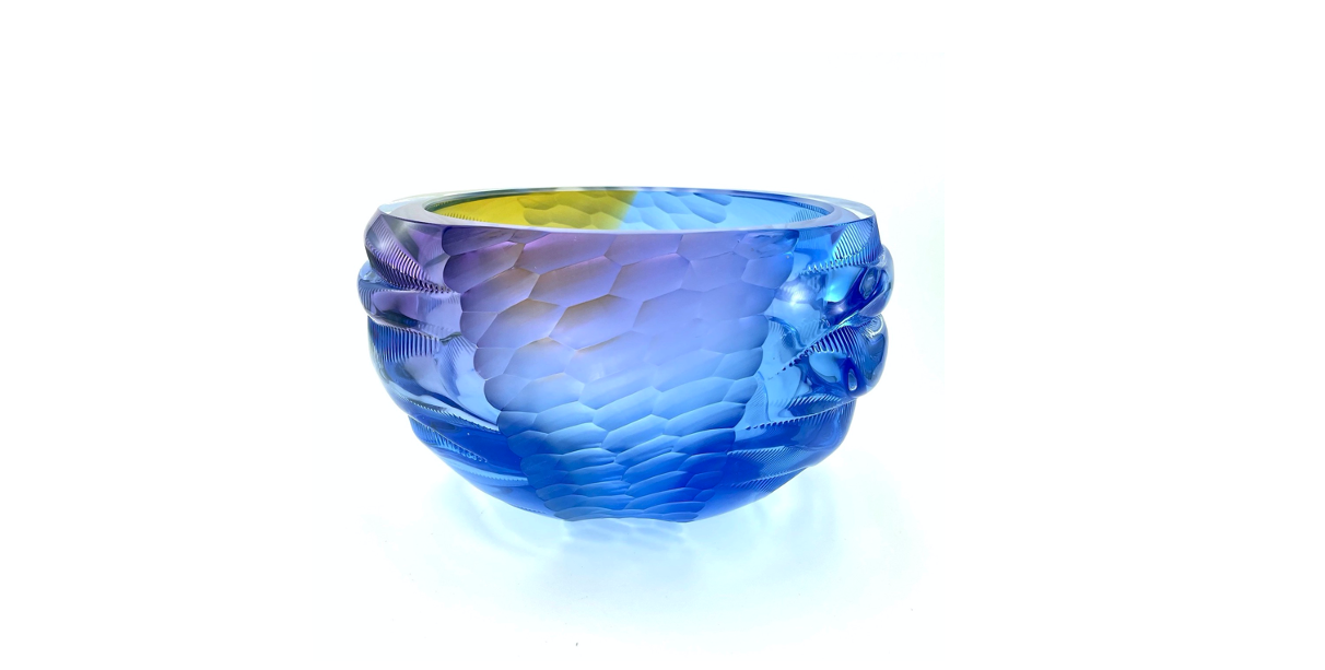 a handblown and carved glass bowl with a textural surface in deep blue.