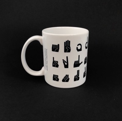 Coffee mug with graphic representations of American Sign Language letter signs.
