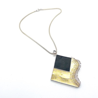 sculptural pendant on braided silver chain.