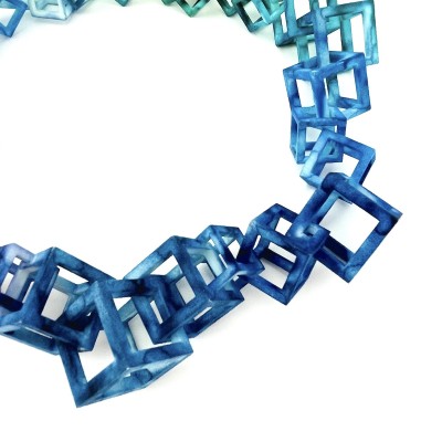 close up of 3D Printed nylon cubes of various sizes hand dyed blue.