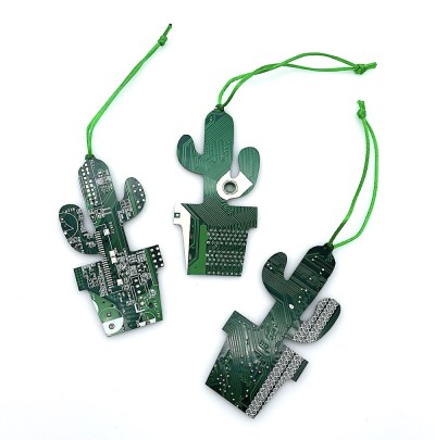 Three green ornaments shaped like a cactus in a pot made of cut circuit board hung on a green string.
