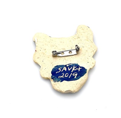 Handmade ceramic pin with whimsical face of a tiger