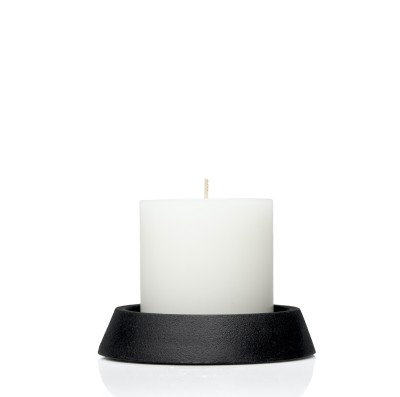 Round black cast iron tray with white candle.
