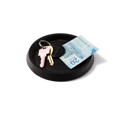 Round black cast iron tray with keys and paper money.