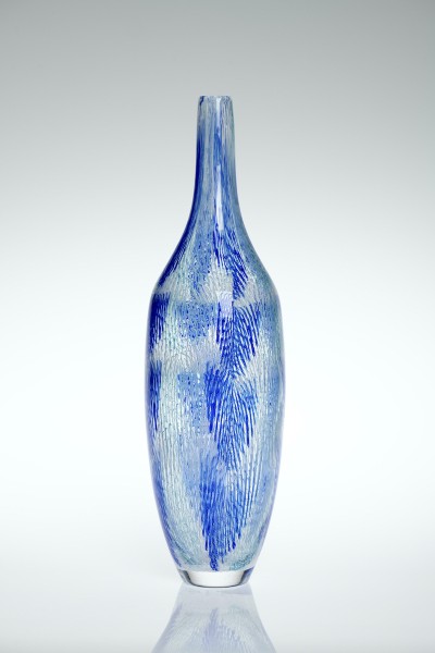 a tall and narrow glass vesel in clear glass with minute blue color hatching that gives the sense of rain drops.