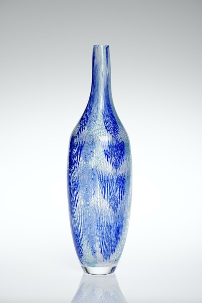 a tall and narrow glass vesel in clear glass with minute blue color hatching that gives the sense of rain drops.