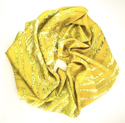 a silk scarf with a striations of colors including chartreuse yellow and white.