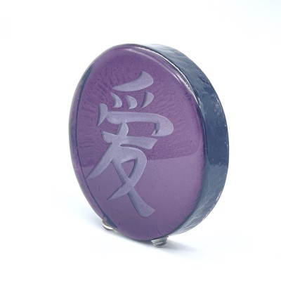 a round purple glass disc with a sandblasted Chinese characture 'Love'.