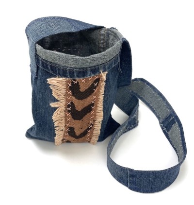 a handsewn blue jean fabric shoulder bag with strips of brown and black chevron patterned African mudcloth..