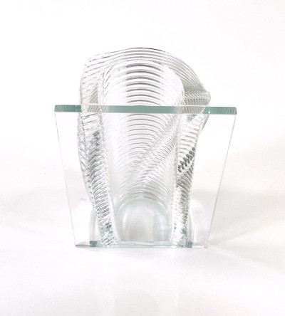 a clear glass vase with a ribbed textural round half and a flat side.
