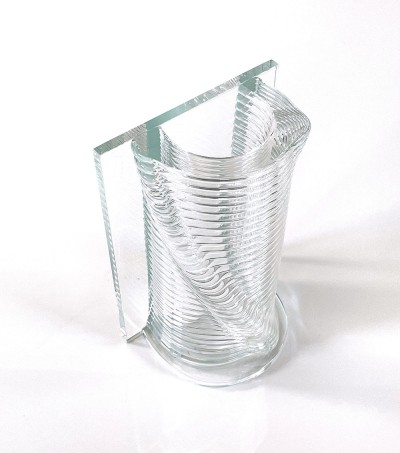 a clear glass vase with a ribbed textural round half and a flat side.