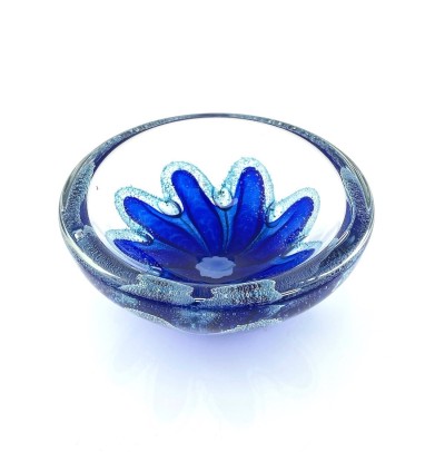 a round clear glass bowl with a starfish like blue design in the center with air bubbles around it.