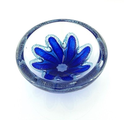 a round clear glass bowl with a starfish like blue design in the center with air bubbles around it.