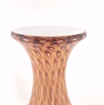 a hand blown teardrop shaped glass vase with a diamond pattern of apricot across the surface with a white interior.