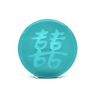 a round green glass disc with the Chinese character 'Double Joy, Double Happiness'.