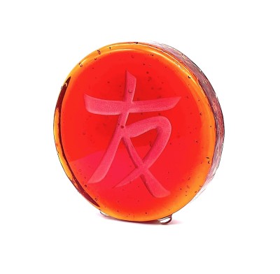 a red round glass disc with the Chinese character 'Friend, Friendship'.