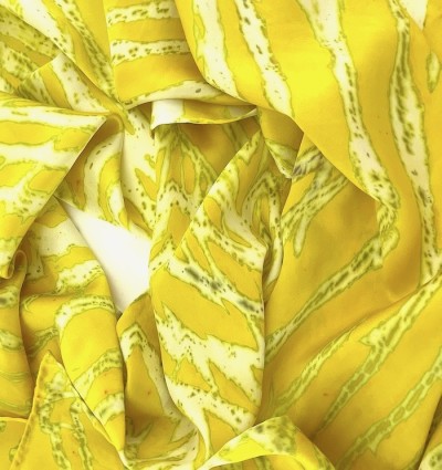 a silk scarf with a striations of colors including chartreuse yellow and white.